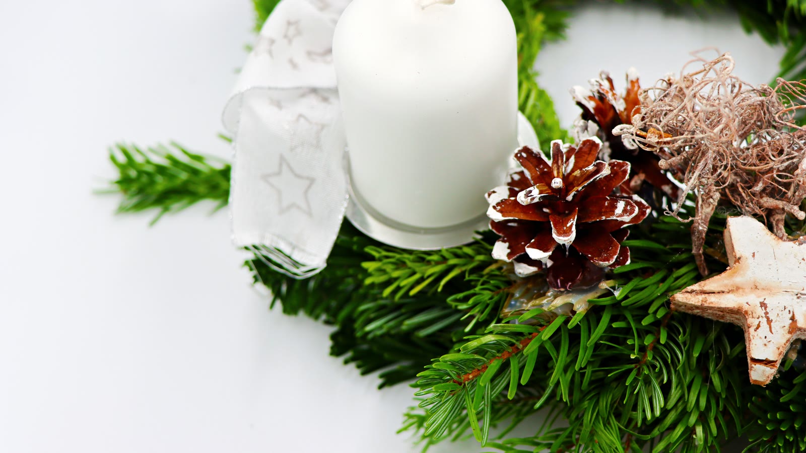 Enkel nordisk adventskrans-detalje med hvidt lys, gran, kogle og træstjerne
